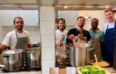 Groepsfoto van kok Lars en anderen in de keuken.