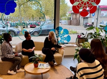 r Tamara, Alice en de stagiaires zitten op de bank te praten