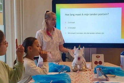 Een tandarts geeft voorlichting in de klas