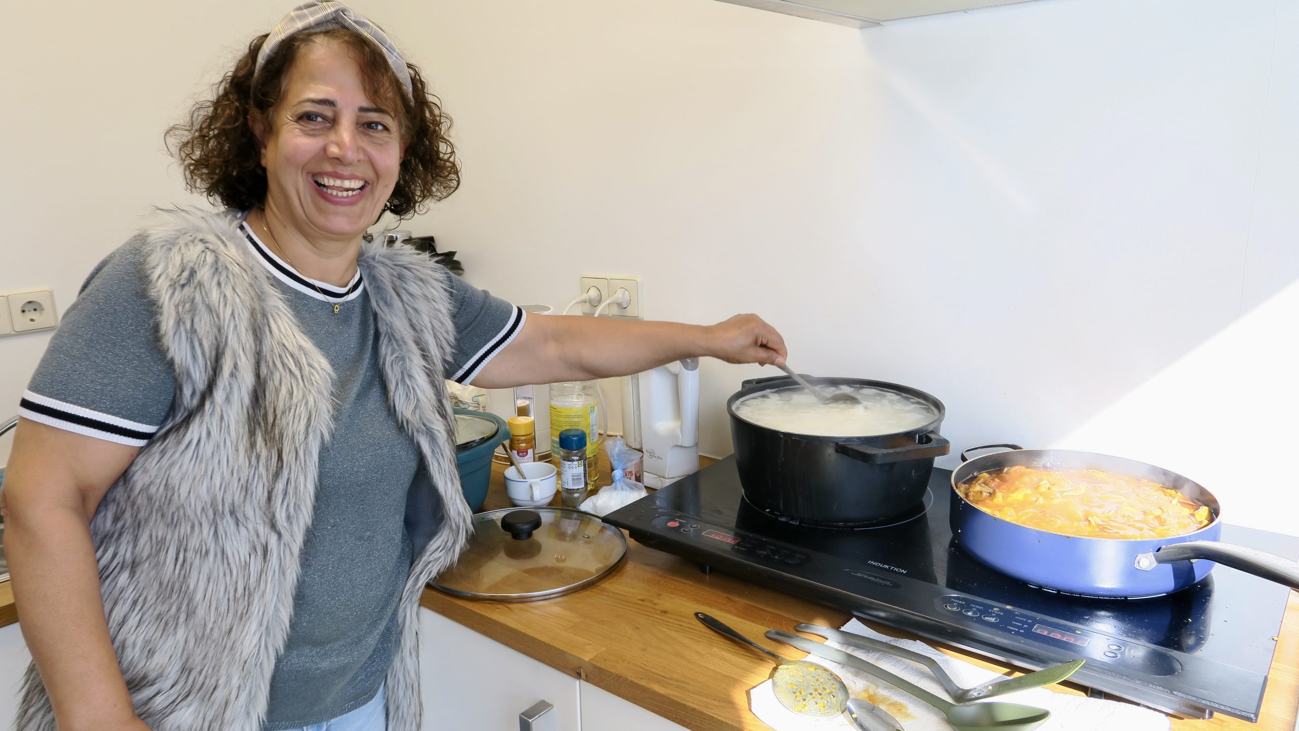 vrouw roert in grote pan voor buurtmaaltijd