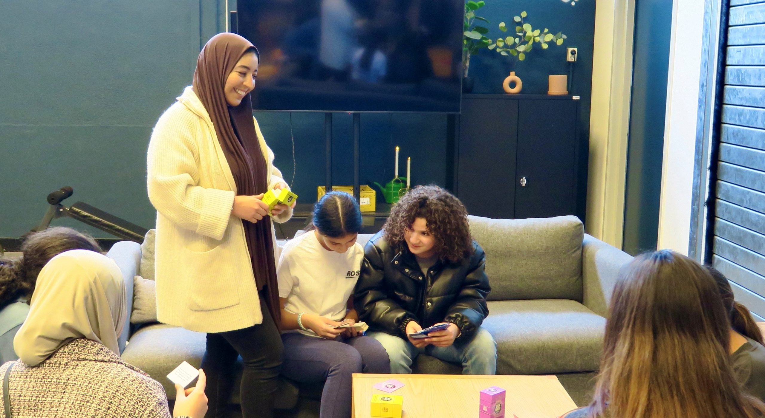 Groep meiden in een algemene ruimte kletsend op een bank