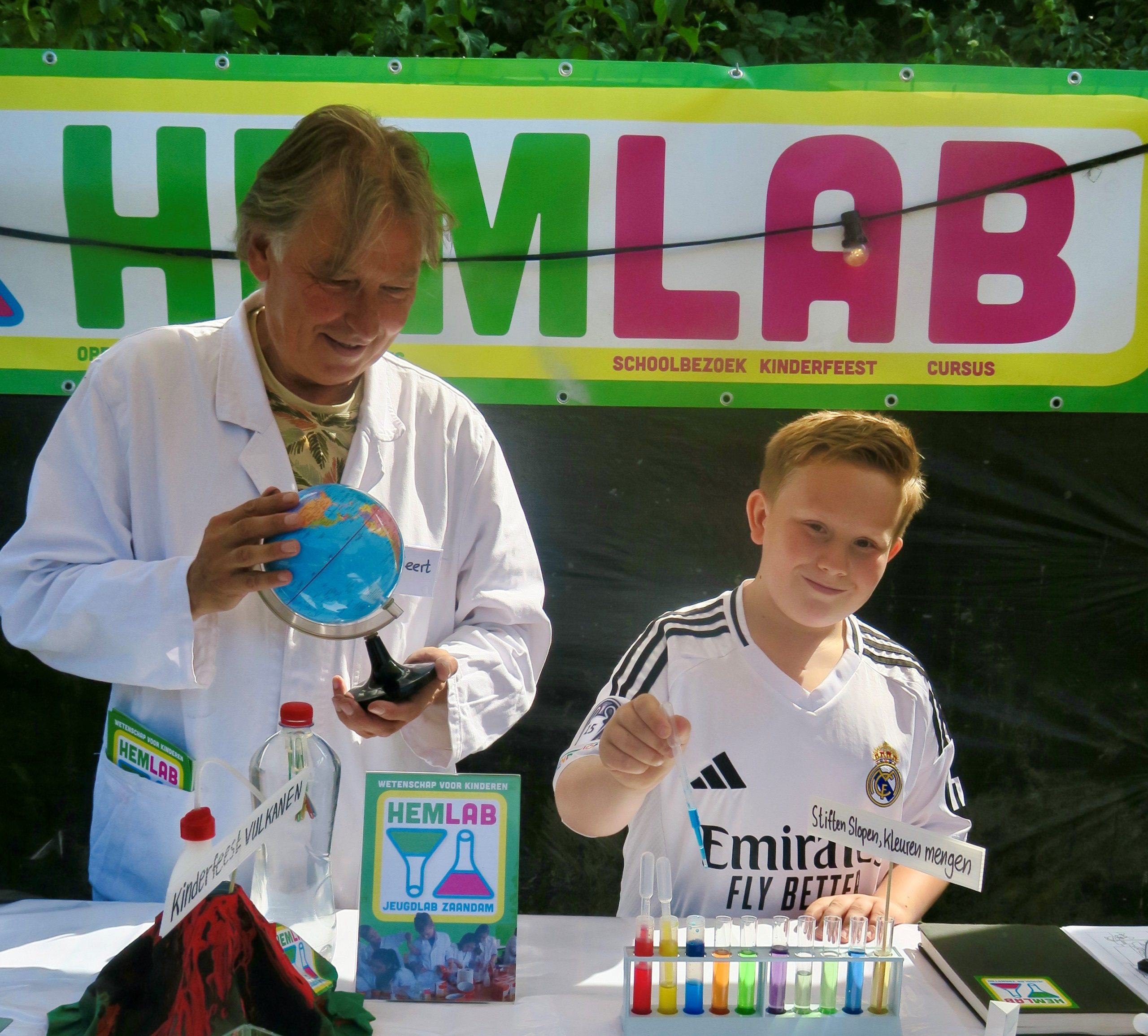 ouder en kind doen proefjes met reageerbuisjes