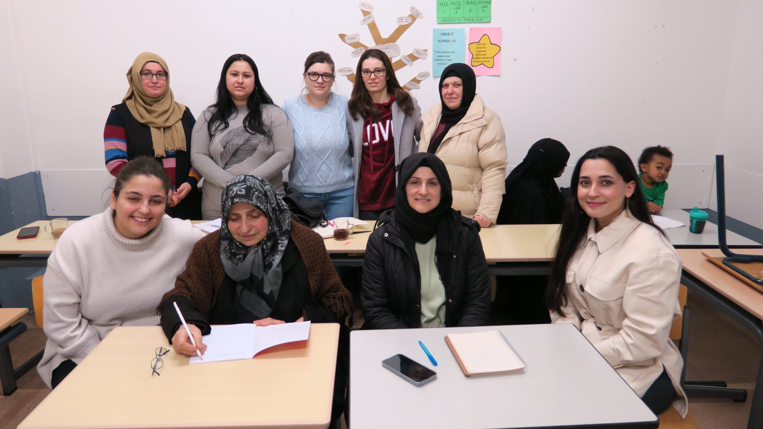 Vrouwen poseren voor tafels in klaslokaal