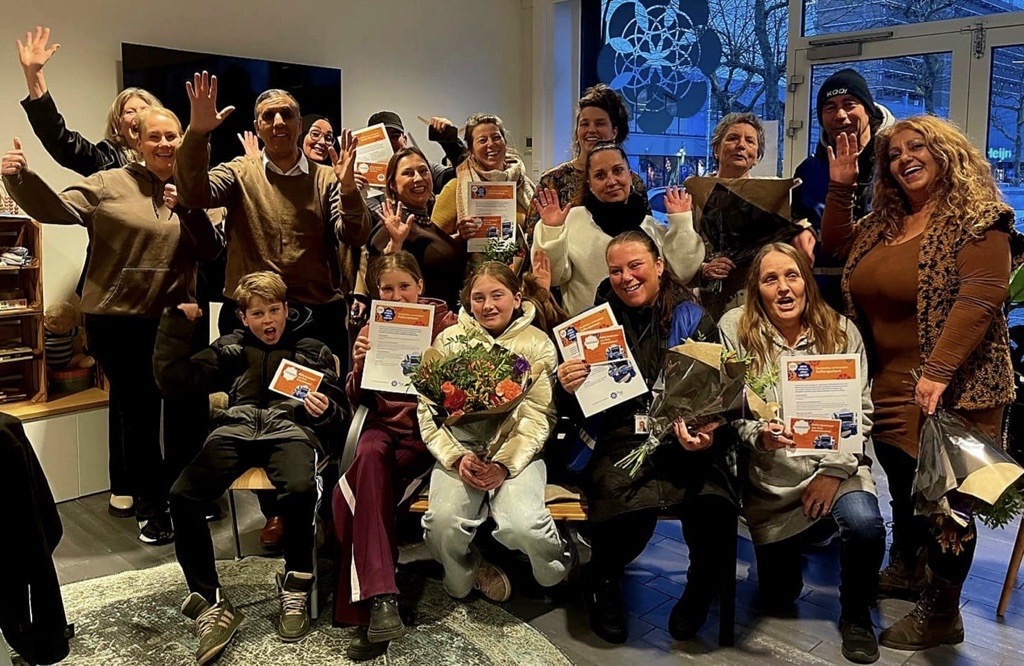 groepsfoto buurtbewoners met bloemen in hun hand