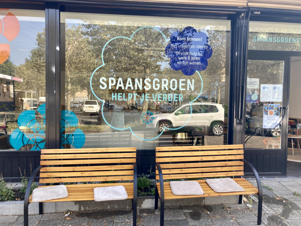 Voorgevel van Spaansgroen met twee bankjes met kussentjes