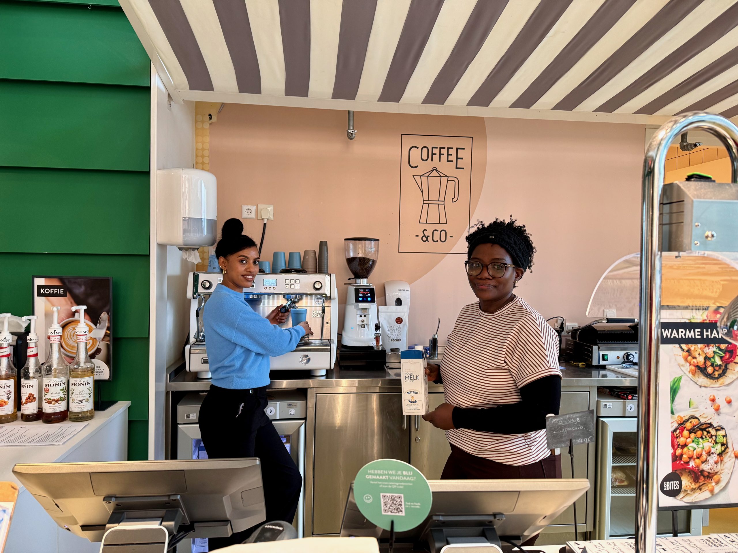 Twee vrouwen zijn aan het werk in een koffiebar